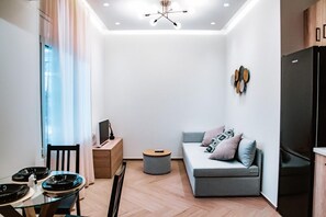 Departamento de lujo, 1 habitación | Área de sala de estar | Televisión 