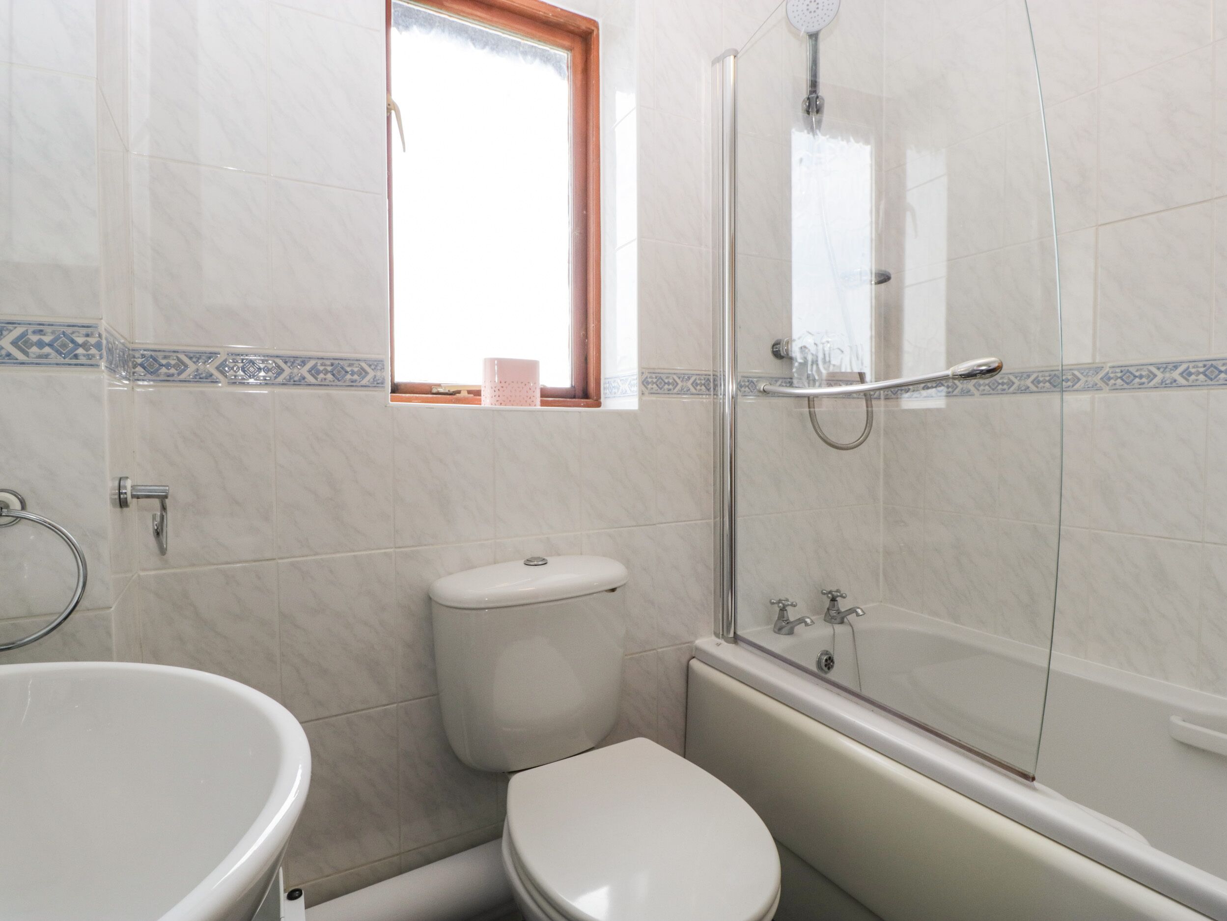 Une salle de bain comprenant des toilettes, une baignoire et un espace douche.