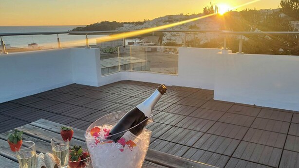 A terrace with a sunset view, a bottle of champagne, ice, strawberries, and blueberries. - Sunset View Apartment - 22 (Albufeira)
