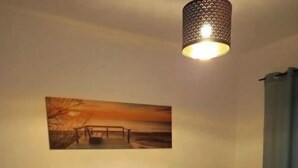 A hotel room with two beds, a painting on the wall, and a lamp. - Sunset View Apartment - 22 (Albufeira)
