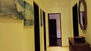 A hallway with a tiled floor, a wooden cabinet, and a mirror on the wall. - Sunset View Apartment - 22 (Albufeira)