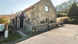 Un bâtiment en pierre avec un toit en pente, une petite fenêtre et une porte.