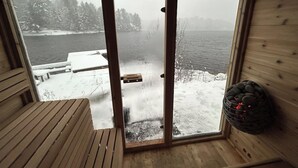 Eine Holzhütte mit einer Bank und einem schwarzen Aufbewahrungskorb.