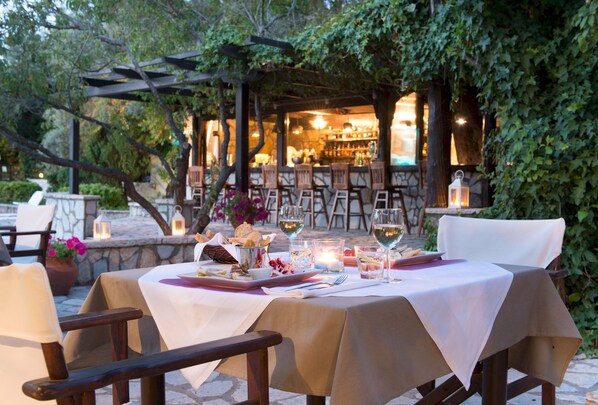 Enjoy a romantic dinner for two under the stars, surrounded by lush greenery and a charming pergola.