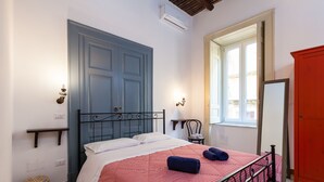 A bedroom with a bed, a window, a wardrobe, and a wall-mounted shelf. - Don Pedro Rooms Vicerè di Toledo - Camera 2 (Napoli)
