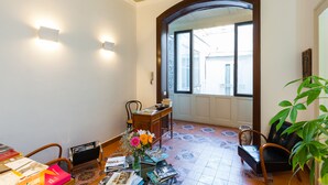 A room with a wooden desk, a chair, a potted plant, and a view through an arched doorway. - Don Pedro Rooms Vicerè di Toledo - Camera 4 (Napoli)