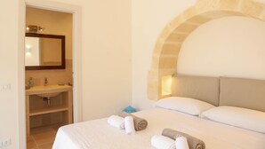 A hotel room with a bed, a bathroom with a sink, and a mirror. - TD Villa Ricchiari Traditional Villa With Designer Pool (Fasano)
