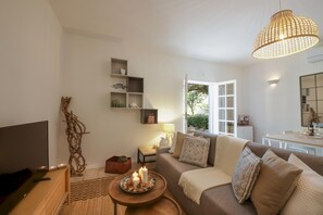 Relax in this inviting living room with a comfortable sofa, coffee table, and large window offering a view of the surrounding greenery.