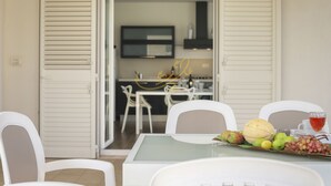 A dining area with a table set for two, chairs, and a variety of fruits and a glass of red beverage. - TD Villa Patrizia Pool Alfresco Kitchen (Monopoli)