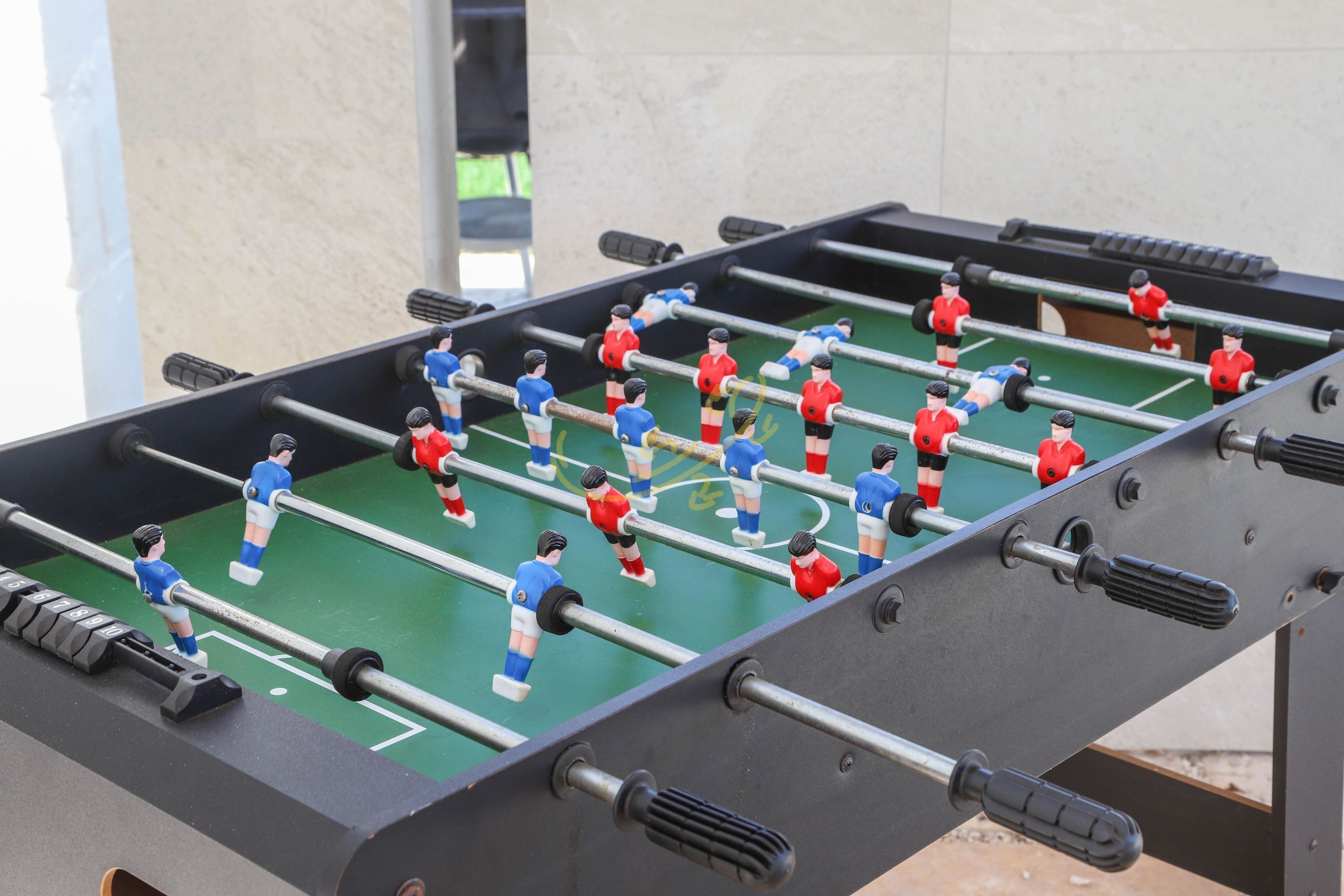A foosball table with players in red and blue uniforms.