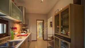 A kitchen with stainless steel appliances, wooden cabinets, and a tiled backsplash.