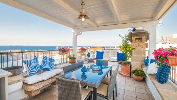 A covered outdoor seating area with a table, chairs, and potted plants. - TD Casa Reina in the Historic Center With Terrace (Polignano a Mare)