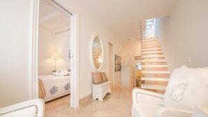 A spacious living area with a high ceiling, a staircase, and a bed with a nightstand. - TD Dimora Arcadia With Breathtaking Sea View (Monopoli)
