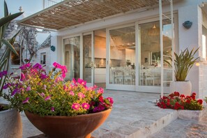 A modern house with a glass door leading to a dining area. - TD Trulli di Bouganville w Large Amazing Pool (Monopoli)