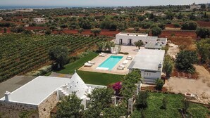 Eine Villa mit Swimmingpool, umgeben von Weinbergen und Olivenhainen, mit Blick auf das Meer.