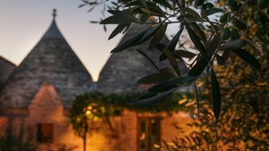 A building with a triangular roof structure, possibly a historical or cultural site. - TD Trulli di Montaltino With Stunning Huge Pool (Polignano a Mare)