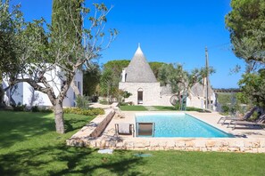 A pool area with stone walls and a stone building in the background. - TD Trulli Tortorella w Nature Pool Sauna (Monopoli)