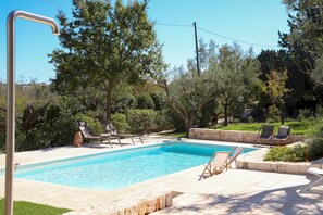 A rectangular swimming pool with a stone border, surrounded by lounge chairs and a stone wall. - TD Trulli Tortorella w Nature Pool Sauna (Monopoli)