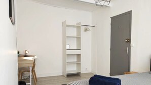Une chambre à coucher avec un lit, un bureau et une armoire.