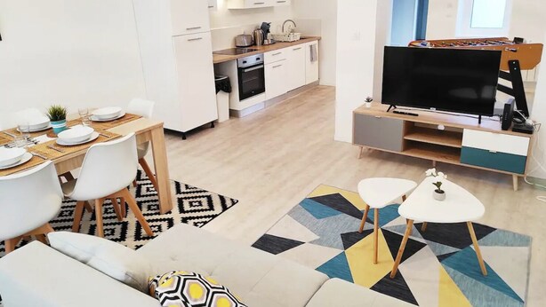 Un appartement moderne comprenant un coin repas, une cuisine et un salon.