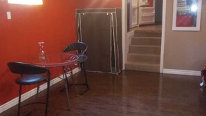 A room with a dining table and chairs, a closed door, and a staircase leading to another level. - COZY APARTMENT FOR RENT GREEN NEIGHBORHOOD (Mississauga)