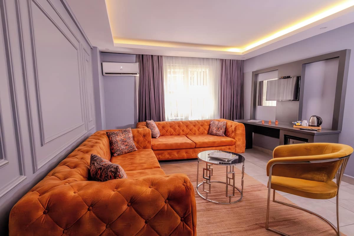 A modern living room with a sectional sofa, a round coffee table, and a yellow armchair.