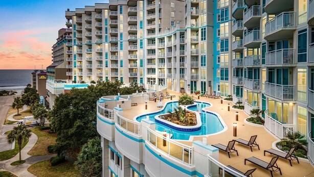 A multi-story hotel with a rooftop pool, balconies, and a view of the ocean. - Horizon at 77th by Elliott Beach Rentals (Myrtle Beach)