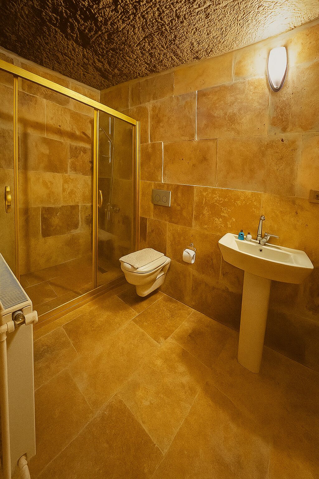 A bathroom with a glass shower enclosure, a toilet, and a sink.