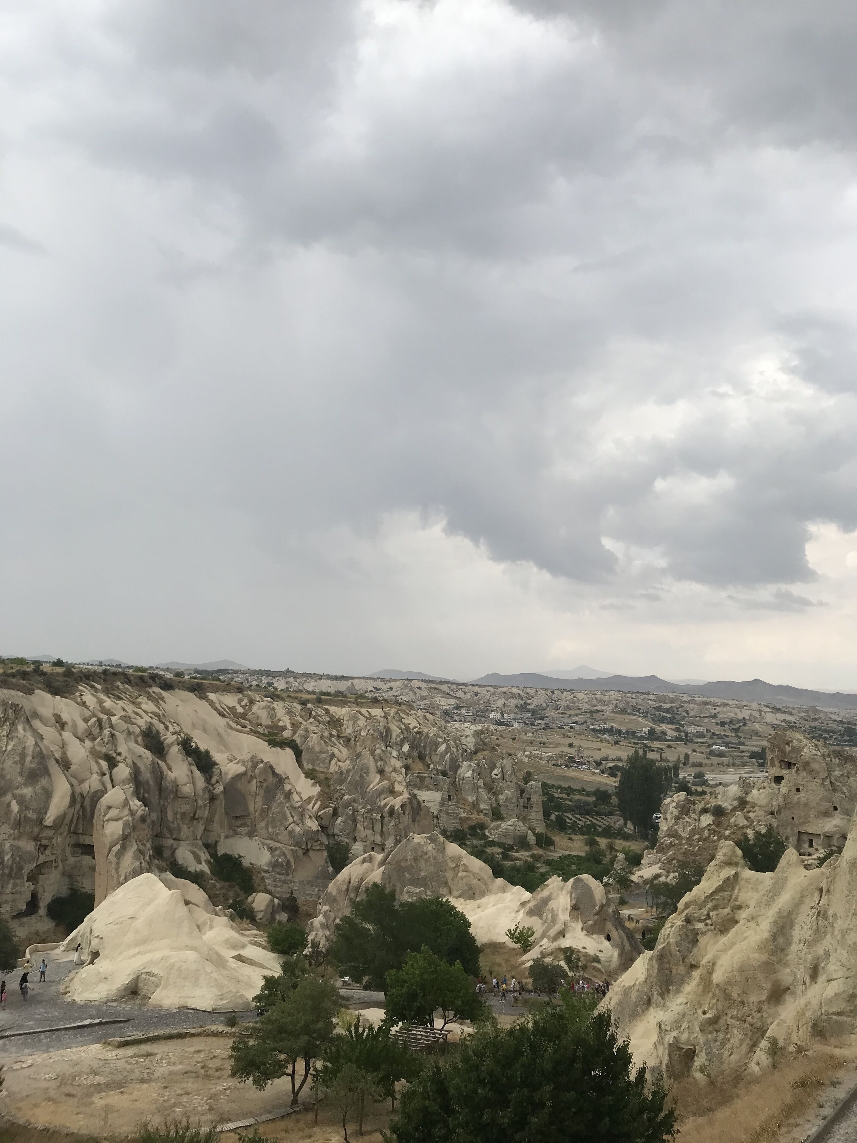 A rocky landscape with large boulders and a distant view of a town.