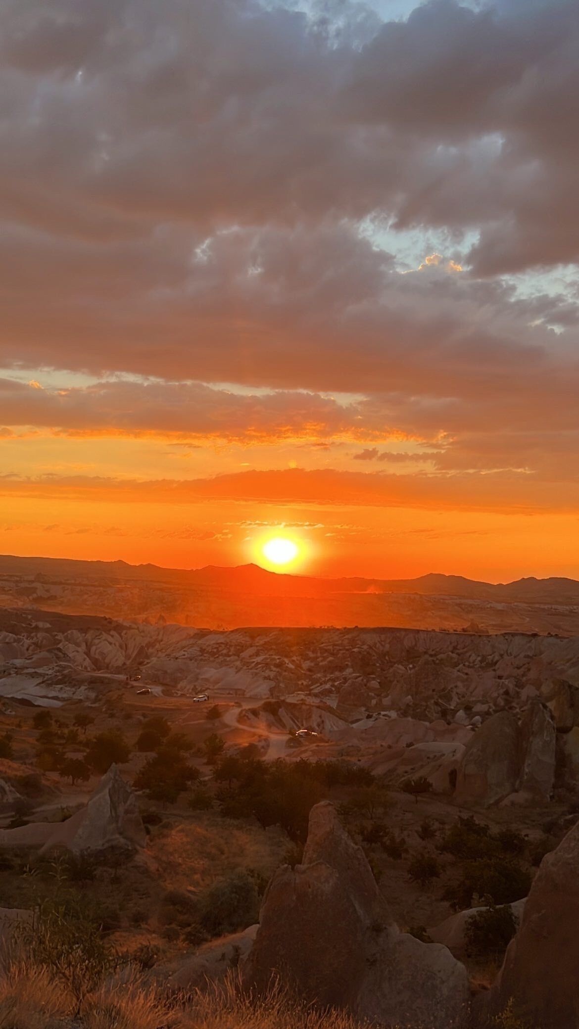 Un atardecer sobre un paisaje rocoso con cielo despejado.
