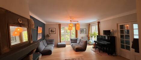 TV connectée, cheminée, table de tennis de table, livres