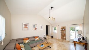 Amplia sala de estar con sofá modular, una mesa de centro y una estantería.