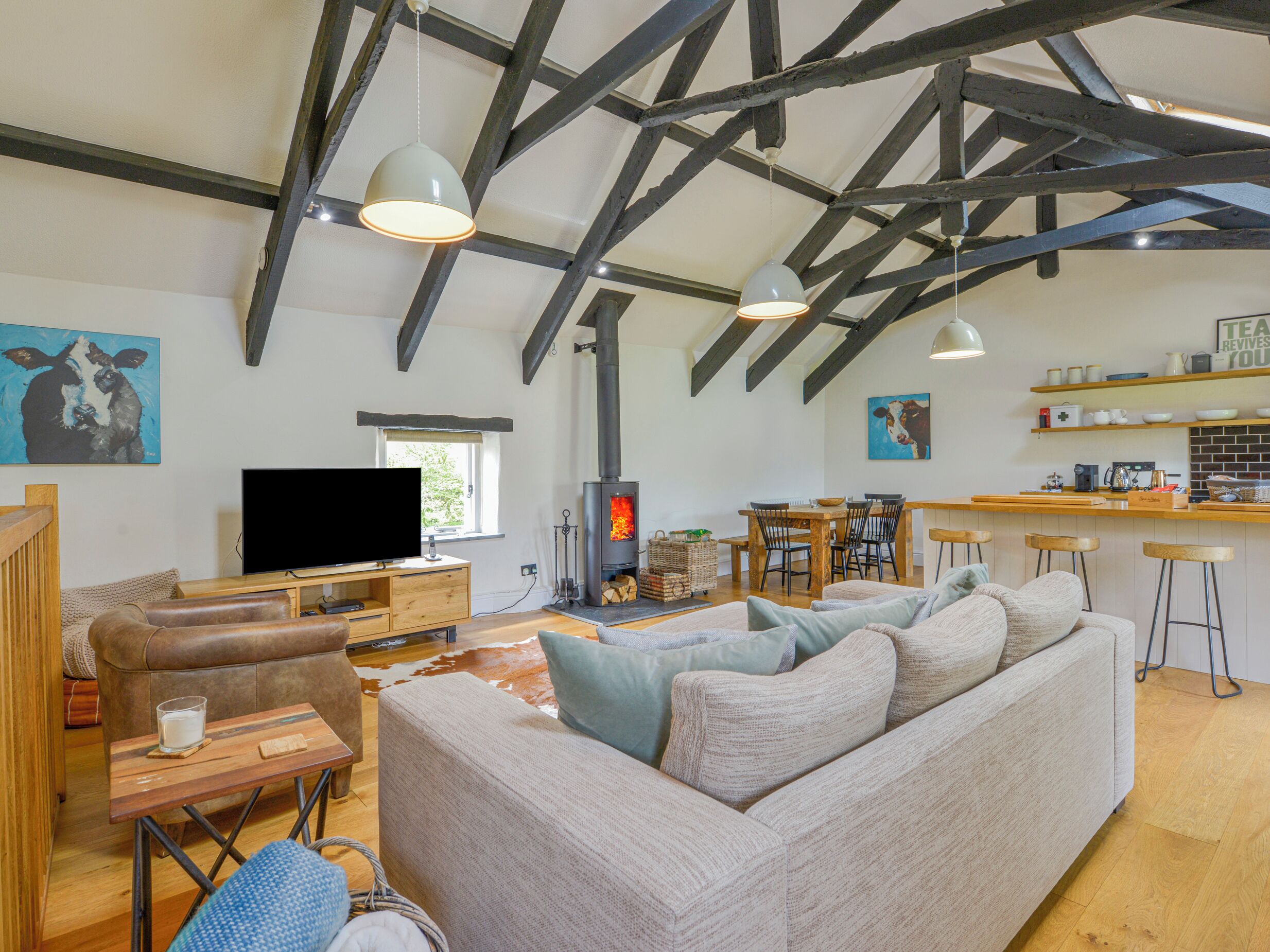 Una sala de estar acogedora con sofá, televisión y chimenea.