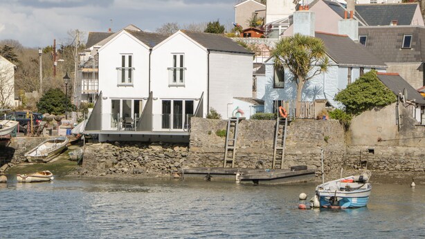 A coastal building with a dock and boats.