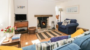 A cozy living room with a fireplace, a television, and comfortable seating.