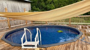 An outdoor swimming pool with a wooden deck, a hammock, and a floating device in the water. - Rustic Tennessee Farmhouse on 100 acres of land (Bethpage)