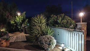 A paved driveway leading to a gated entrance with a well-maintained garden and a street lamp. - Appart-hôtel-piscine (Fréjus)