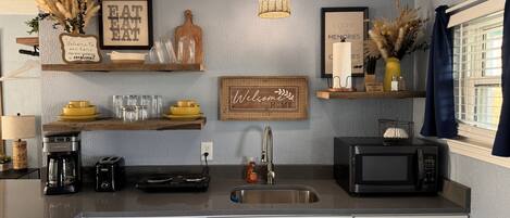 Fridge, microwave, coffee/tea maker, cookware/dishes/utensils