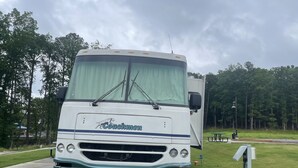 Een witte camper met het logo "Coachmen" op een gazon.