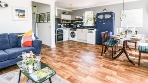 A compact living space with a kitchen, dining area, and a sofa. - Kilmartin View (Lochgilphead)