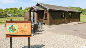 A wooden cabin with a porch and a signboard in front. - Kilmartin View (Lochgilphead)
