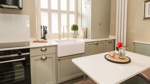 A modern kitchen with a built-in oven, a sink, and a countertop with various kitchen items.