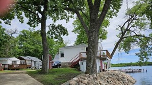 Une propriété au bord du lac comprenant une maison, un quai et un mur de soutènement en pierre.