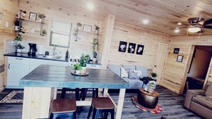 Un intérieur en bois comprenant une table à manger, des chaises, un canapé et une petite table basse.