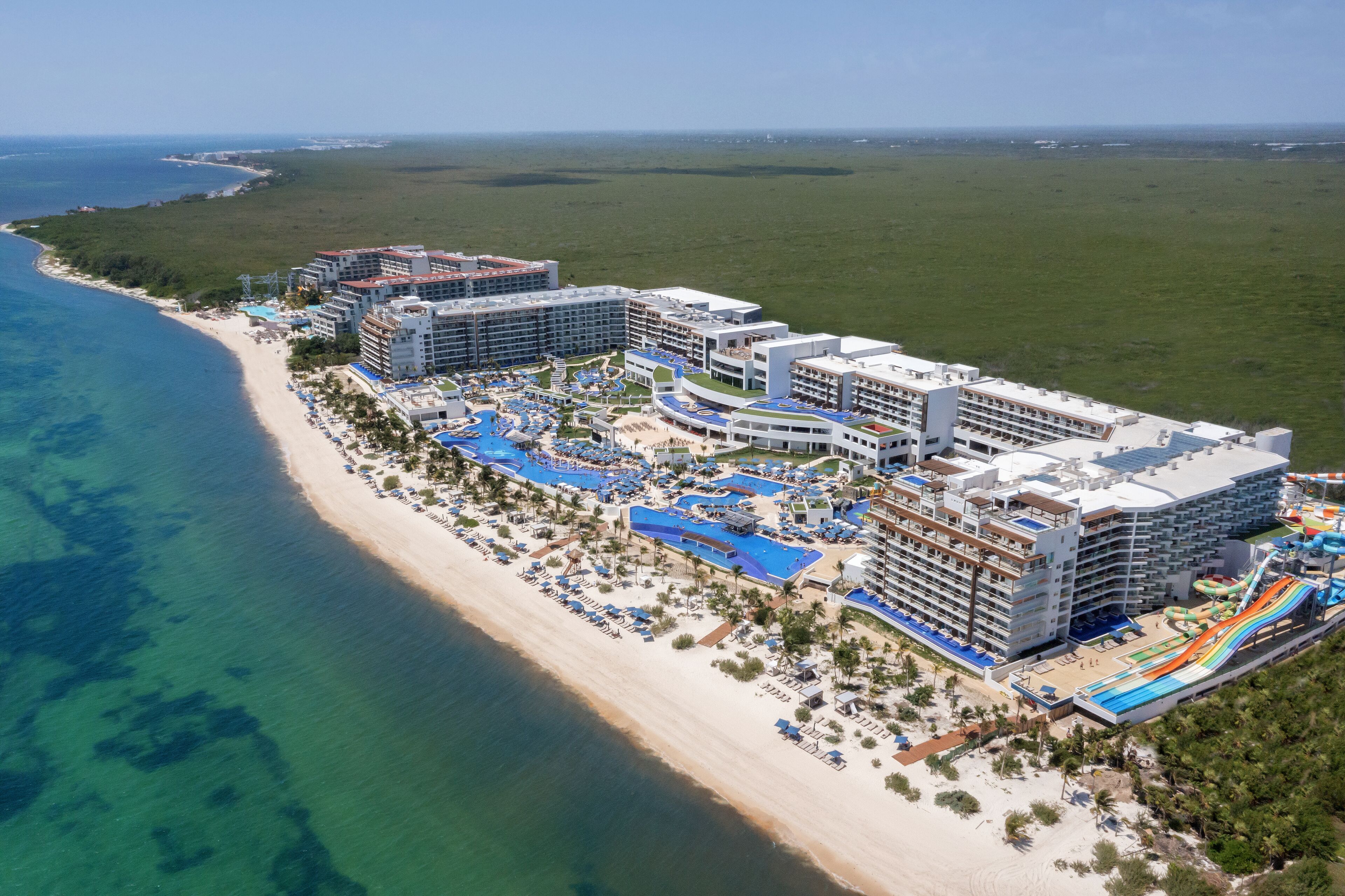 A resort with multiple buildings, a beach, and a water park.
