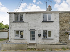A two-story house with a stone facade, a white door, and a small porch. - Cysgod Y Coed (Machynlleth)