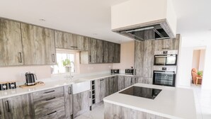Une cuisine moderne avec des meubles en bois, un îlot central et des appareils électroménagers intégrés.