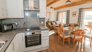 A modern kitchen with stainless steel appliances, a dining area with wooden furniture, and a cozy living space with a fireplace.