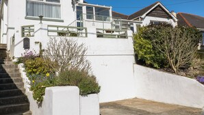 Ein weißes, zweistöckiges Haus mit Balkon, kleinem Garten und der Hausnummer 40.