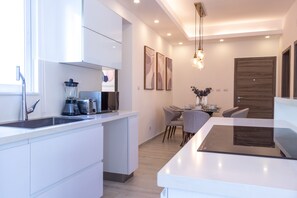 Departamento familiar | Cocina privada | Cafetera de espresso, tetera eléctrica y comedor 
